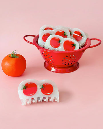 white hair claw with tomato design and rhinestone detail in a red strainer