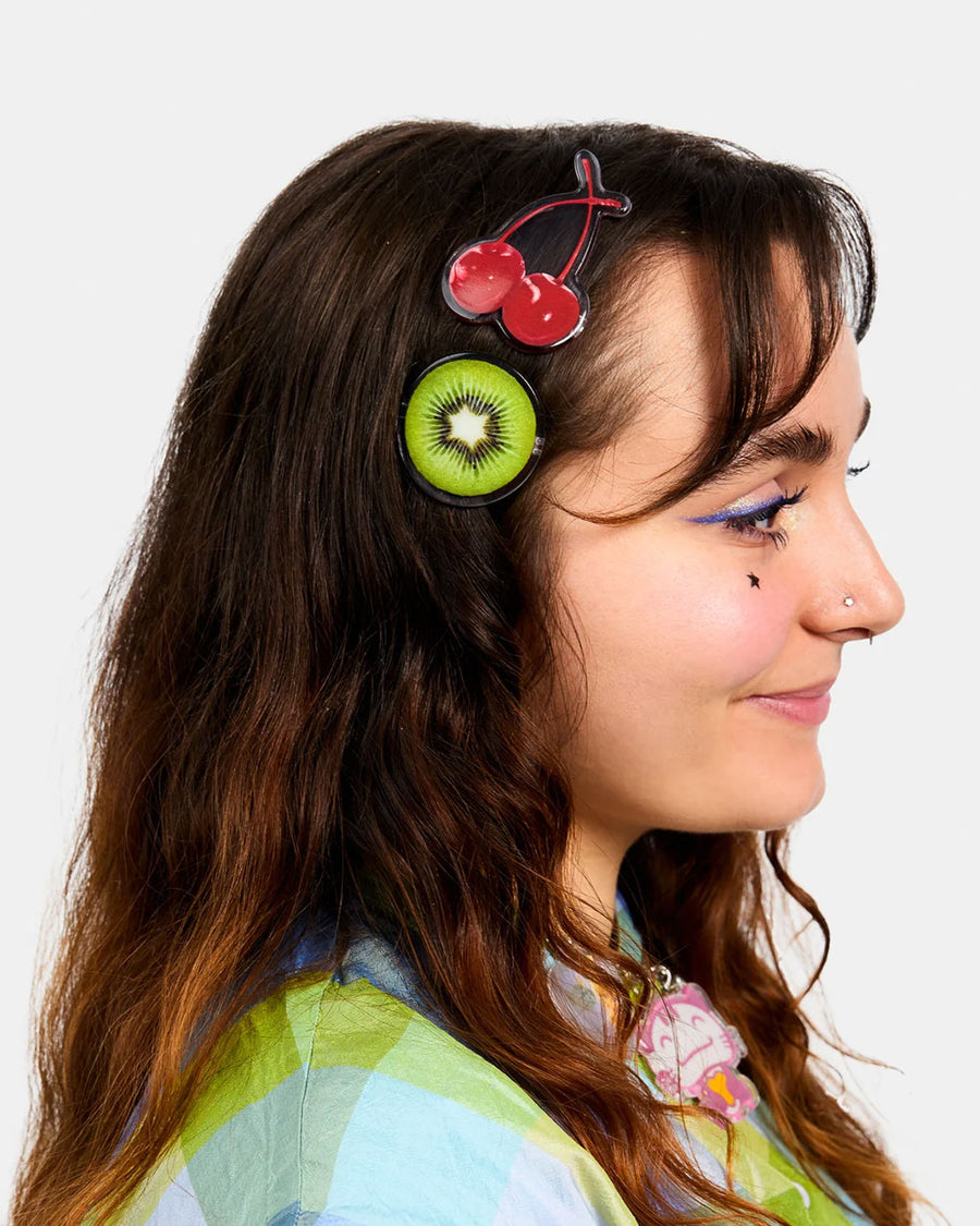 model wearing set of three realistic fruit print clips: yellow starfruit, kiwi, and cherries