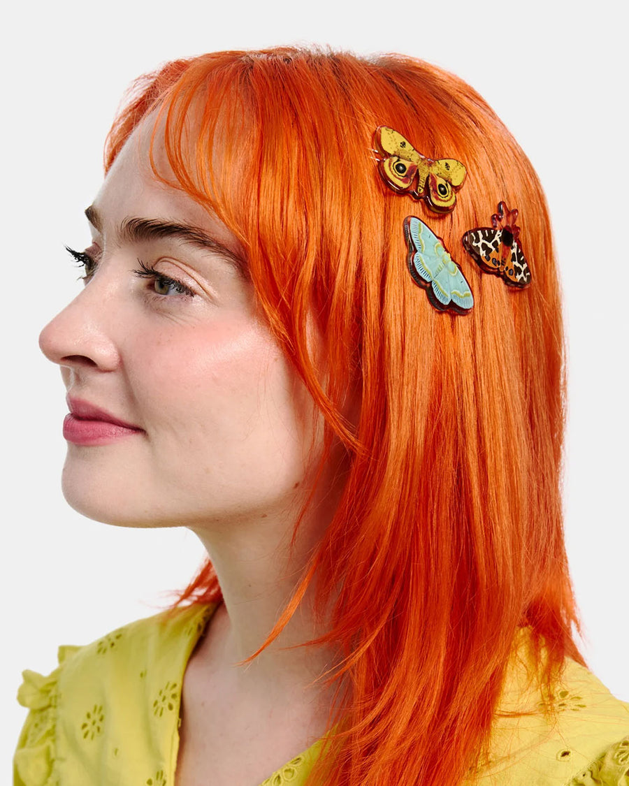 model wearing set of three realistic moth print hair clips