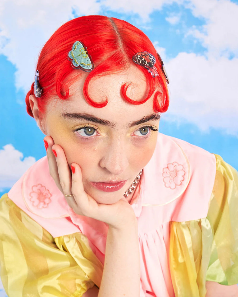 model wearing set of three realistic moth print hair clips