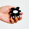 model holding black and white flower shaped hair claw