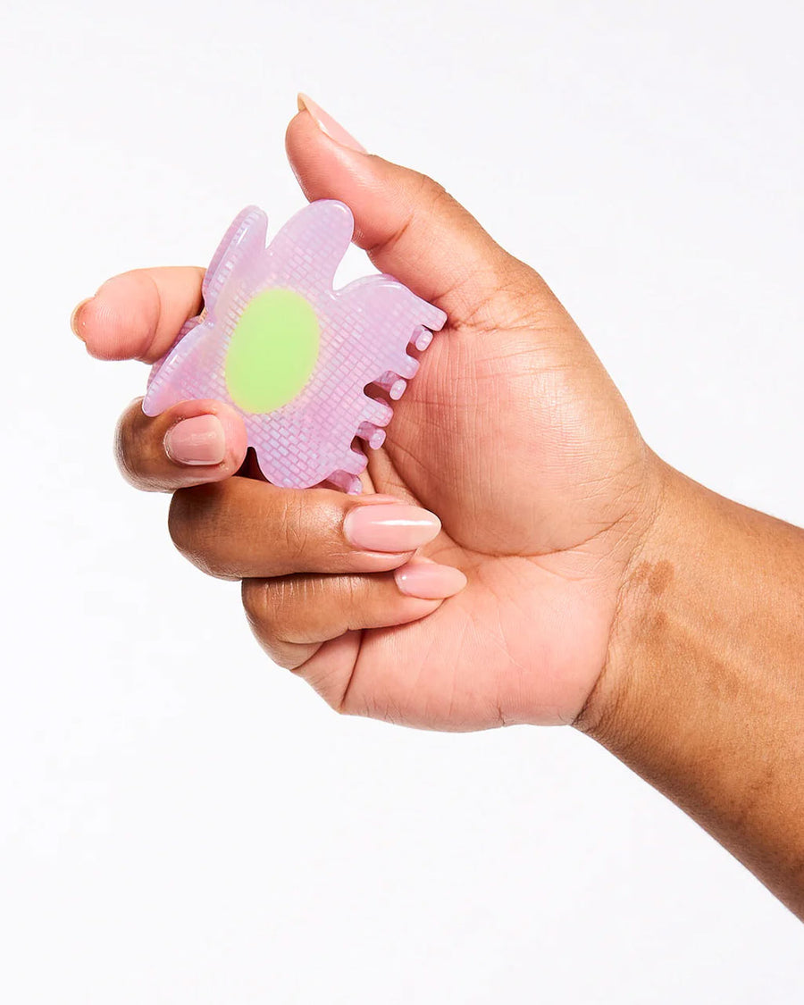 model holding shimmer lilac flower hair claw with yellow/lime center