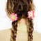 model wearing two pink and yellow flower shaped hair claws in their hair