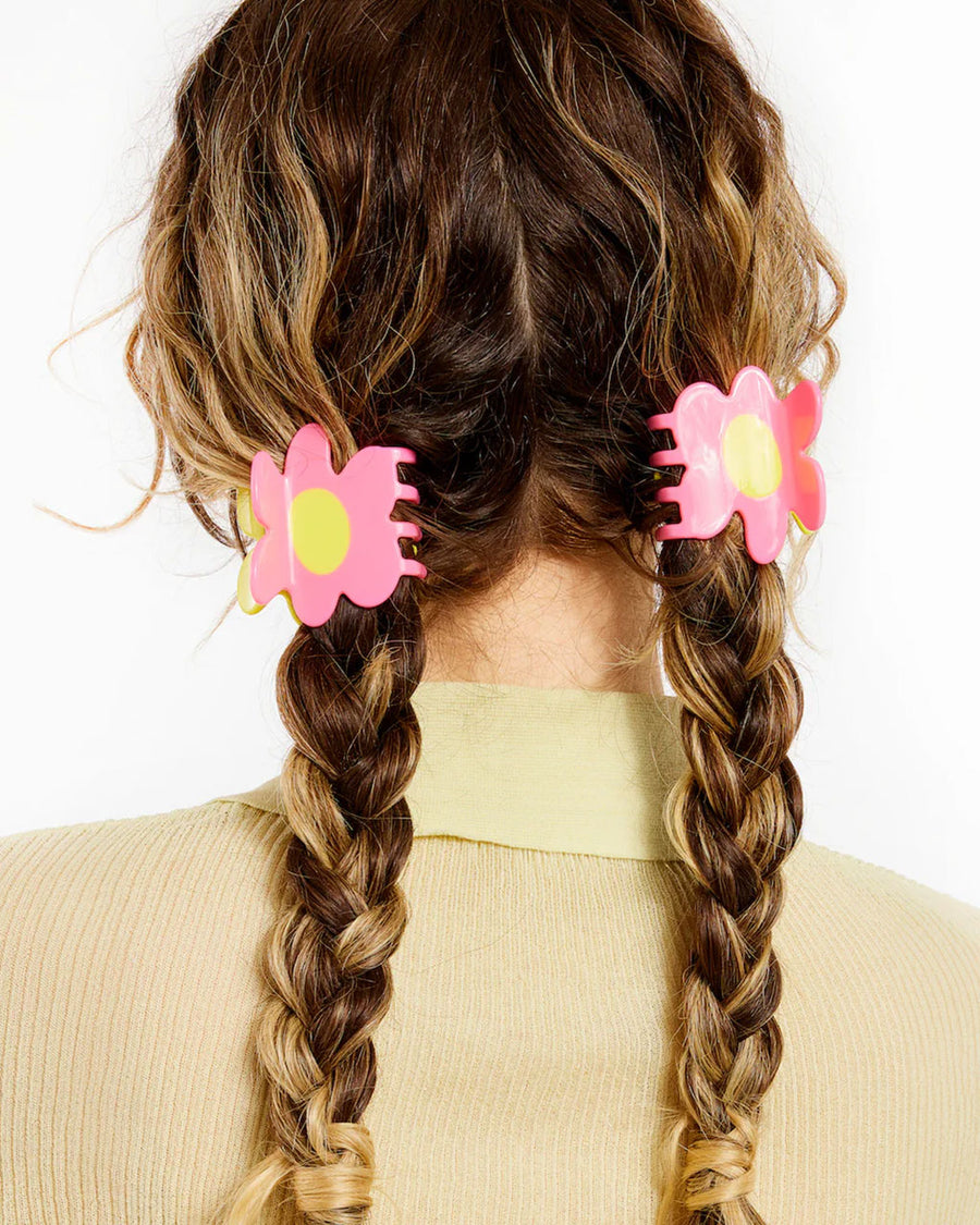 model wearing two pink and yellow flower shaped hair claws in their hair