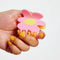 model holding pink and yellow flower shaped hair claw