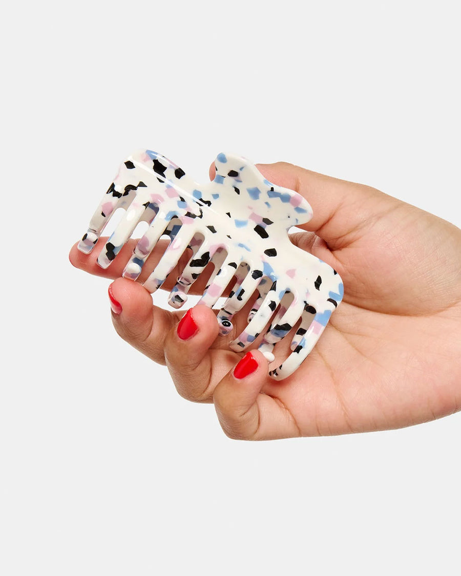 model holding white small hair claw with blue, pink and black terrazzo print