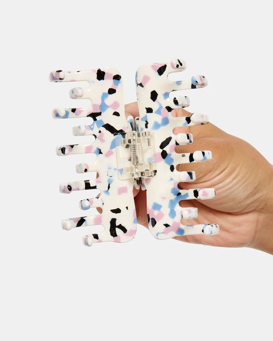 model opening up white small hair claw with blue, pink and black terrazzo print