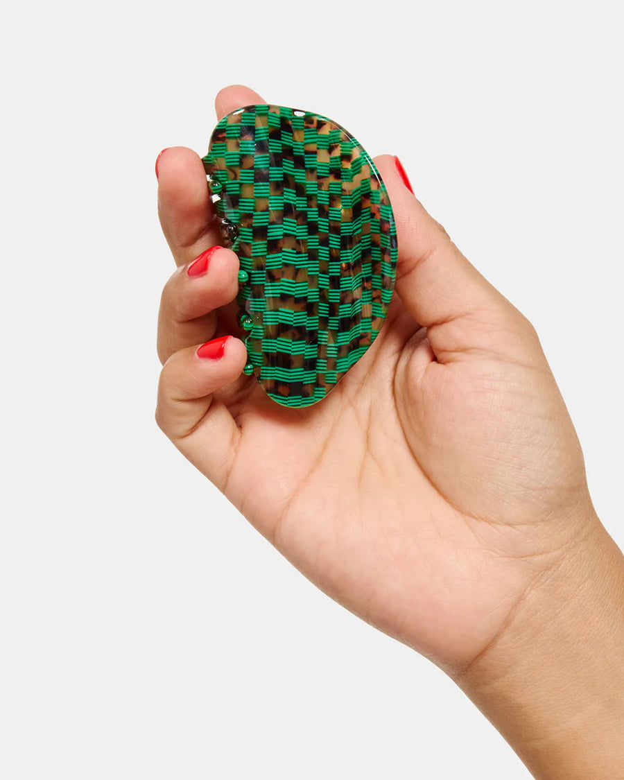 model holding emerald green and turquoise checkered hair claw