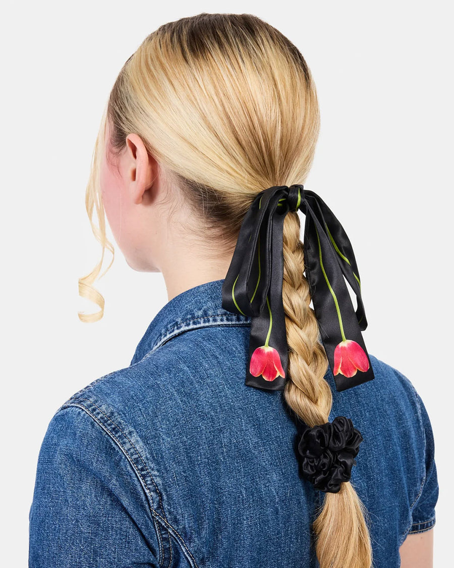 model wearing black pink tulip silk tie with matching black silk scrunchie in their hair