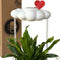 white cloud shaped houseplant waterer with red heart charm in a potted plant