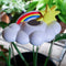 top view of white cloud shaped houseplant waterer with sun and rainbow charm in a potted plant