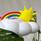 up close of white cloud shaped houseplant waterer with sun and rainbow charm in a potted plant