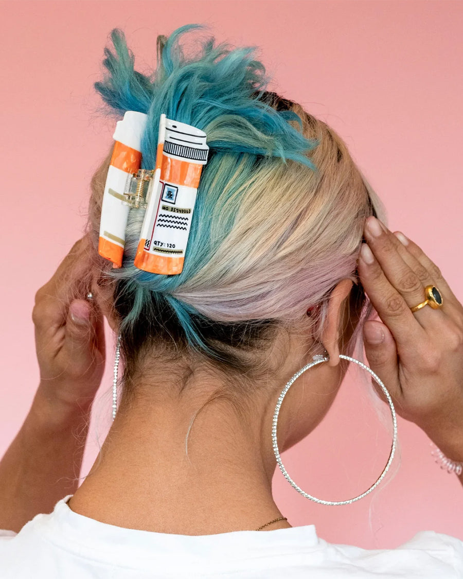 model wearing orange prescription bottle hair claw