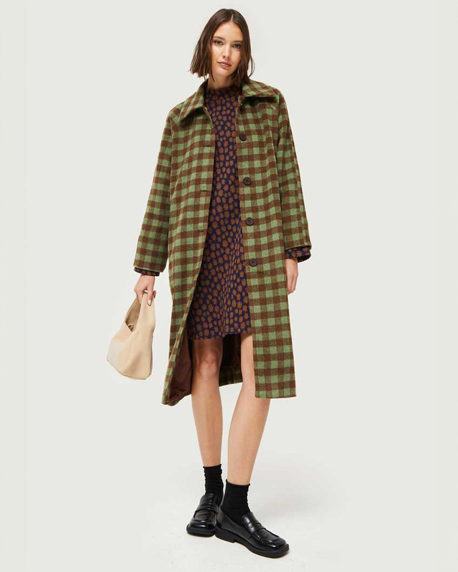 model wearing green and brown checkered midi coat