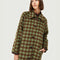 up close of model wearing green and brown checkered midi coat