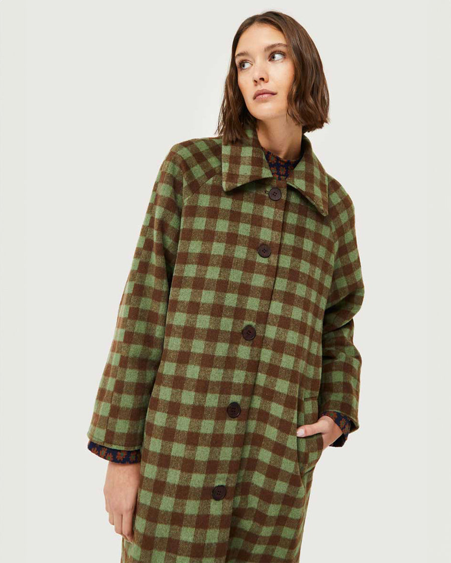 up close of model wearing green and brown checkered midi coat