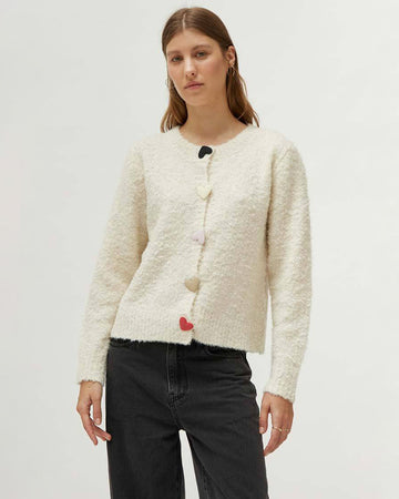 model wearing creme fuzzy cardigan with multicolor heart shaped buttons