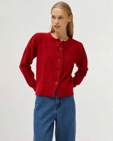 model wearing red cardigan with a tie around the neckline