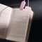 lilac clip on booklight lit and on a book