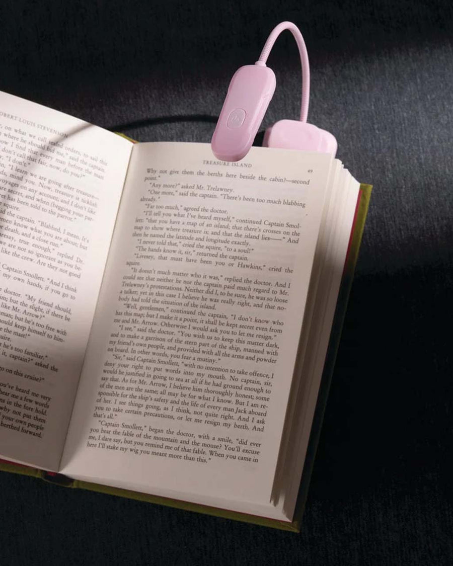 lilac clip on booklight lit and on a book