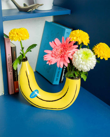 banana shaped vase with flowers on each side