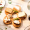 wooden daisy shaped serving board with various cheeses on it