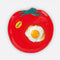 tomato shaped plate with yellow 'ripe' sticker on the left side with an egg on it