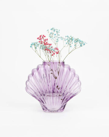 purple glass seashell shaped vase with dainty flowers inside