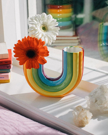 rainbow shaped vase with flowers in the one end