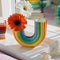 rainbow shaped vase with flowers in the one end