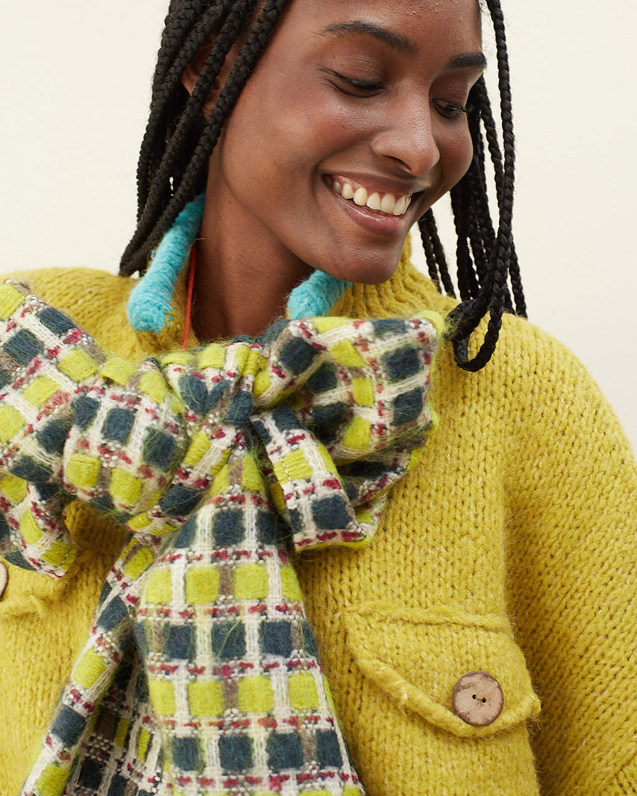 up close of model wearing yellow and green checkered scarf