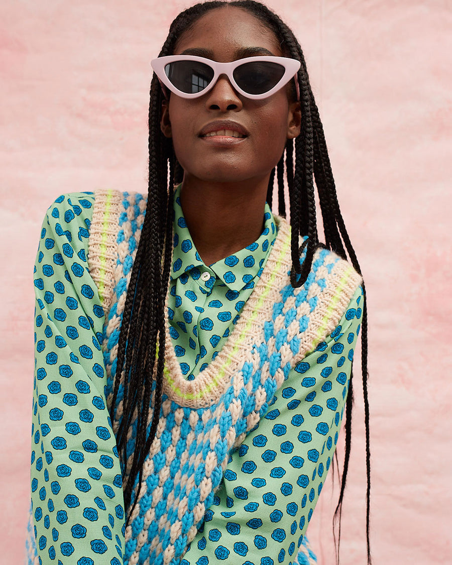 up close of model wearing pink and blue textured sweater vest with slight blouson bottom