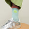 up close of model wearing blue socks with neon smiley on the cuff