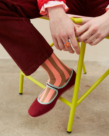 model wearing pink and brown vertical stripe socks