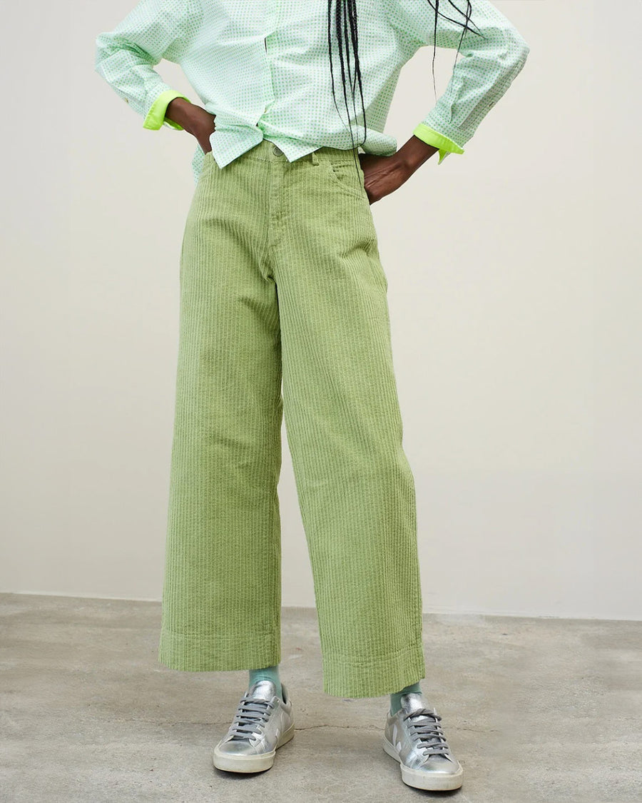 model wearing sage corduroy pants with slight wide leg