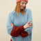 model wearing light blue sweater with maroon cuffs and orange neckline