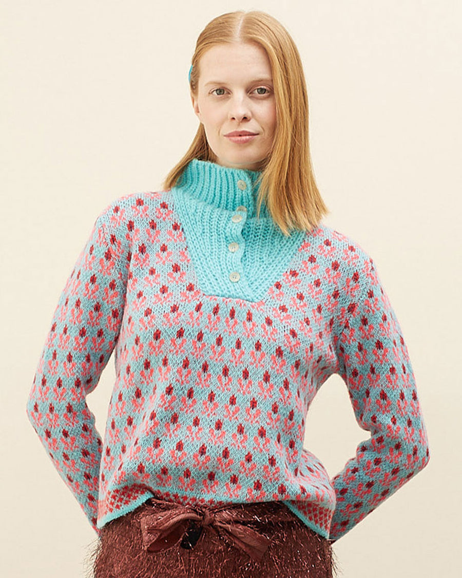 model wearing blue sweater with button funnel neckline and pink abstract floral print