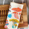 folded cream tea towel with colorful mushroom print