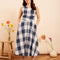 model wearing indigo and white plaid midi dress with wrap waist and thick tank straps