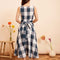 back view of model wearing indigo and white plaid midi dress with wrap waist and thick tank straps