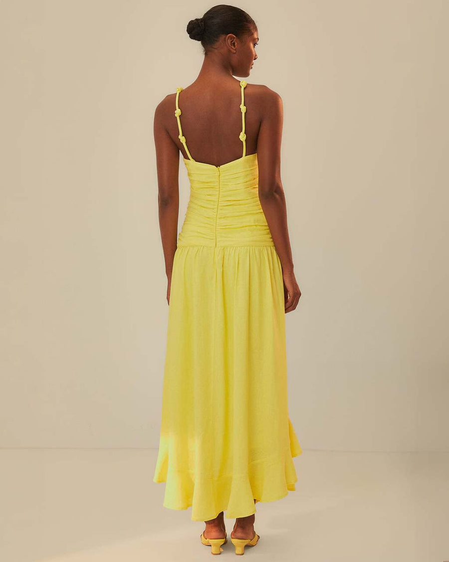 back view ofmodel wearing yellow dress with criss cross bodice and knots in the straps