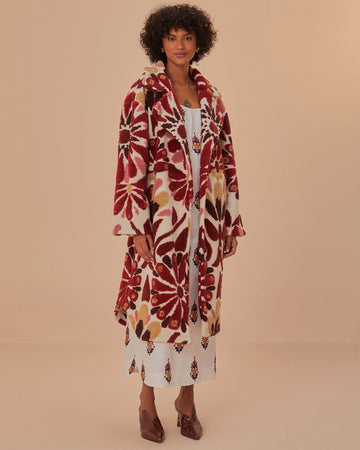 model wearing fleece midi length coat with red and gold abstract floral print