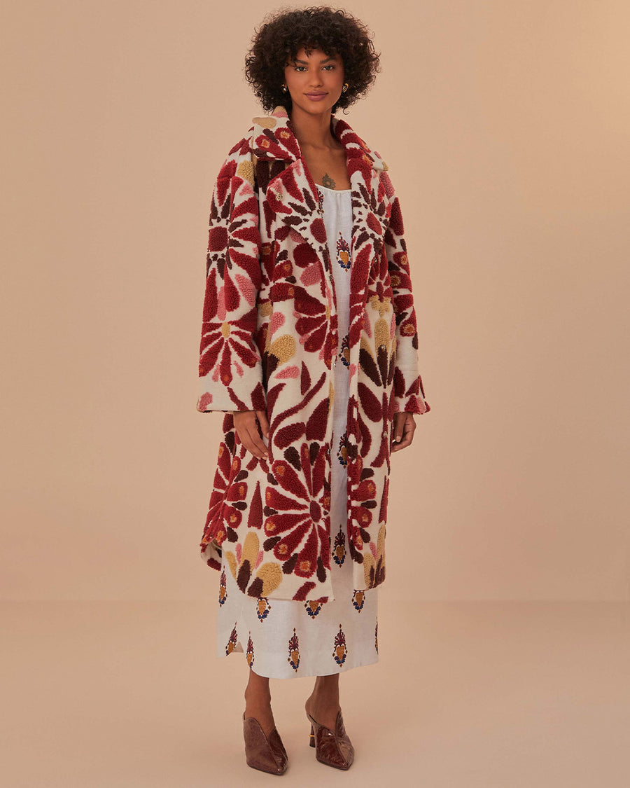 model wearing fleece midi length coat with red and gold abstract floral print