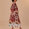 side view of model wearing fleece midi length coat with red and gold abstract floral print
