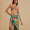 model wearing teal beach sarong with colorful banana and banana leaves print and green fringe