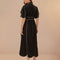 back view of model wearing black cotton midi dress with scallop hem and white piping