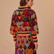 back view of model black sweater with colorful abstract hearts and striped mock neck, sleeve cuffs and hem