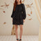 model wearing black long sleeves mini dress with crocheted detail and tie waist