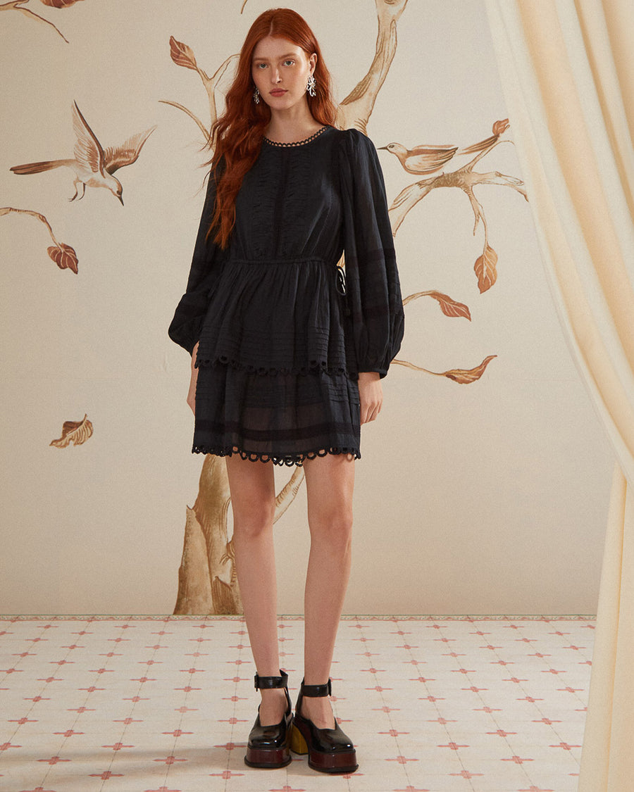 model wearing black long sleeves mini dress with crocheted detail and tie waist