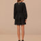 back view of model wearing black long sleeves mini dress with crocheted detail and tie waist